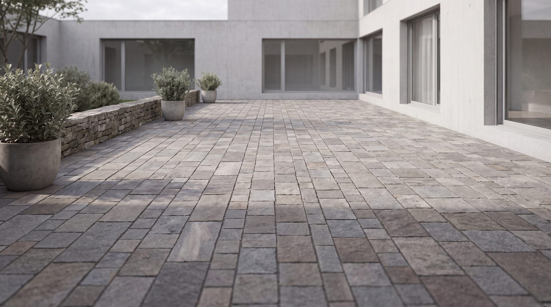 A paver patio laid in a running bond, long shadows, no furniture